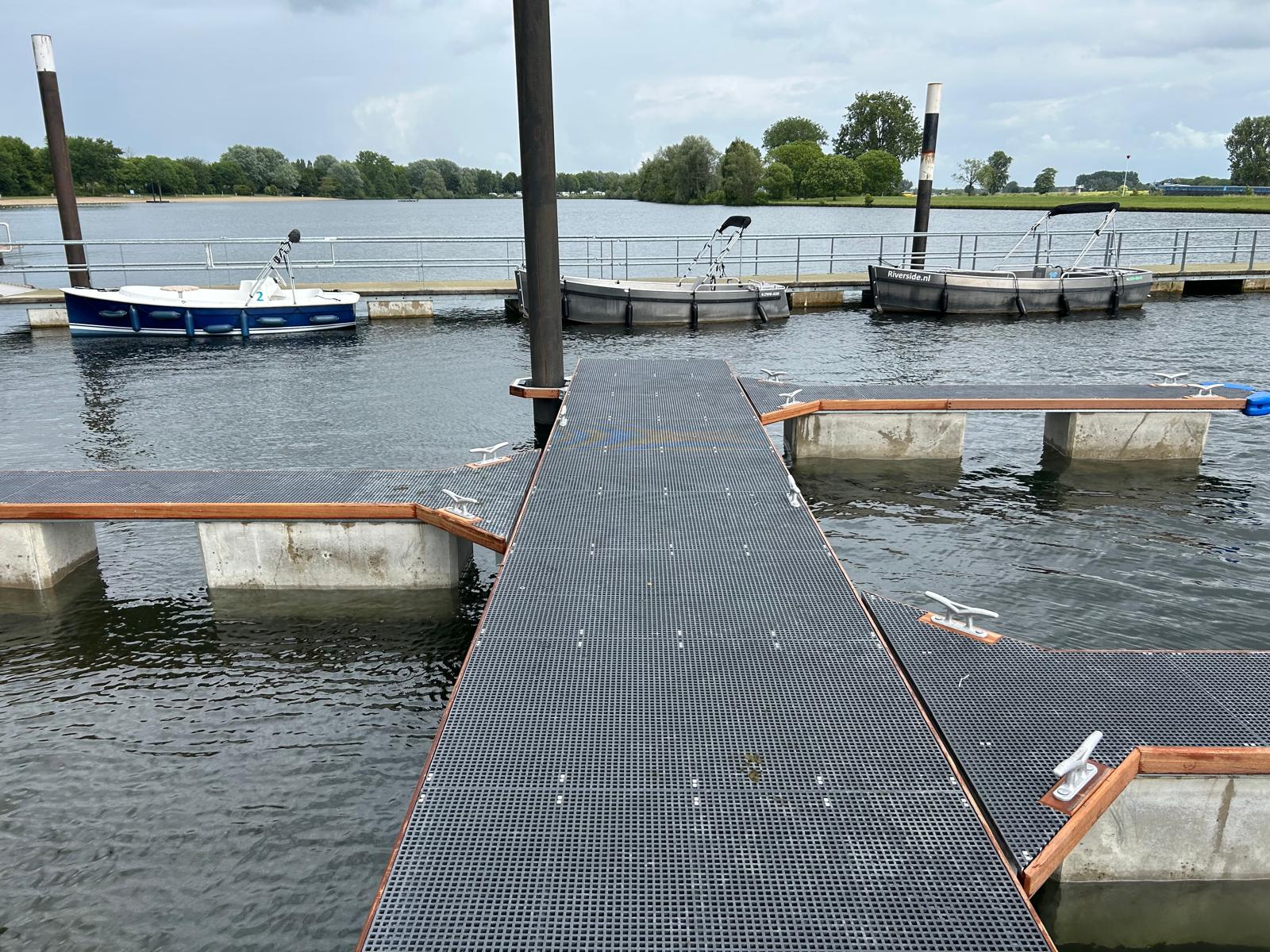 Nieuwe drijvende Walcon steiger van 23 meter lang bij Riverside Appeltern. Voorzien van kunststof roosters. Gemonteerd door W2 Support. Achtergrond een drijvend looppad te zien voor Gemeente West Maas en Waal.